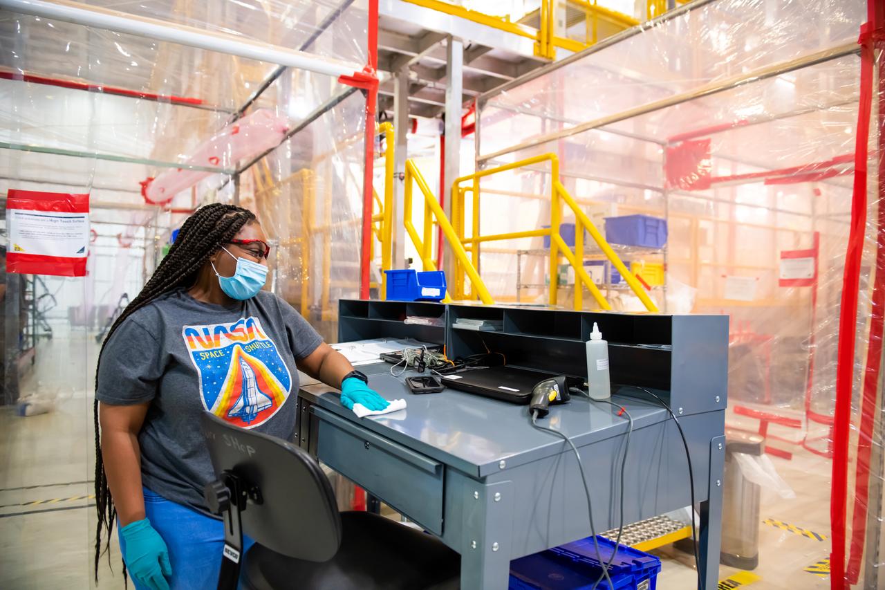 Employees wear personal protective gear at  Michoud Assembly Facility as the facility transitioned to Stage 3 of NASA’s Framework for Return To On-Site Work. Employees wear the appropriate personal protective equipment (PPE) and/or cloth face coverings as required for assigned tasks. Access to the facility is limited to authorized personnel working on mission-critical tasks that must be conducted onsite. Mission-critical tasks include slowly and methodically resuming Space Launch System (SLS) Core Stage and Orion production activities, particularly critical path deliverables to support the Artemis Program, at a pace that limits personnel and follows federal guidelines for social distancing and use of personal protective equipment such as face masks. For more information about SLS, visit nasa.gov/sls.